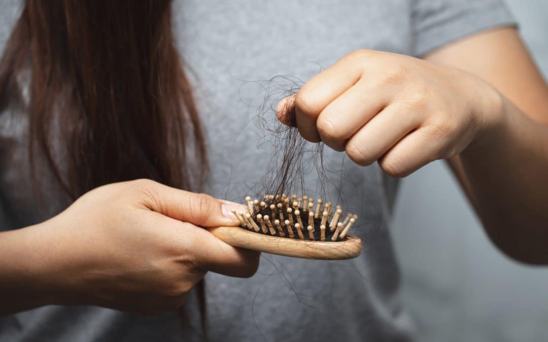 Lady pulling hair on a brush