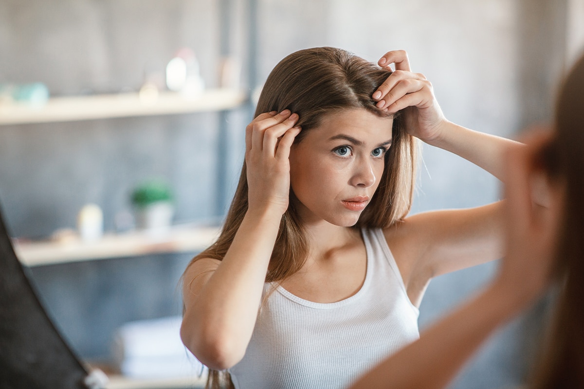 Lady in the mirror checking for thin hairline